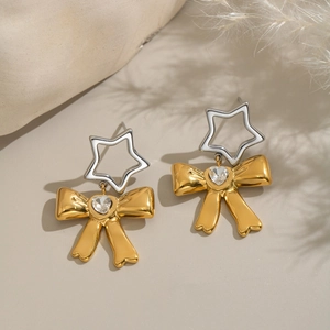 Orecchini a fiocco bicolore con zircone a cuore su sfondo beige minimalista