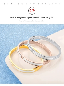 Detail of 18K gold-plated stainless steel bangles with white enamel inlay and crystals