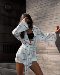 Detail of white satin kimono cardigan with black letter print and belted waist design