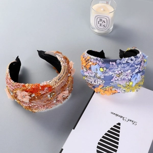 Detail of wide sequined headbands with handmade floral embroidery and pearls