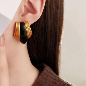 Close-up of vintage French gold and black enamel earring worn on a model's ear