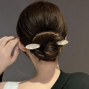 Leaf-shaped rhinestone hair pin in gold finish shown on a bun hairstyle for women