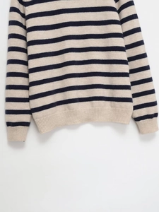 Detail shot of navy and cream striped knit sweater featuring ribbed hem and sleeve cuffs
