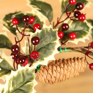 Christmas wreath branch with red berries pine cones and frosted holly leaves decor