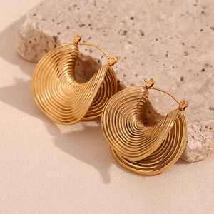 Macro shot of gold-plated C-shaped earrings with unique spiral layered texture details