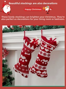 Detail of red and white knitted Christmas bone stockings with snowflake and paw print patterns