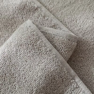 Macro detail of high-density cotton towel showing soft fibers and reinforced stitched edges