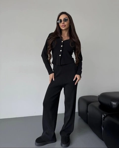 Close-up of black ribbed knit lounge set featuring buttoned cardigan and wide-leg pants