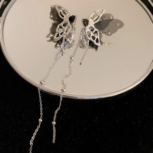 Detail view of dark style silver butterfly earrings with black mesh and long bead tassels