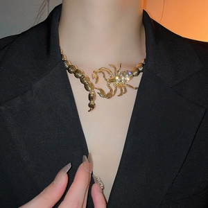 Close-up of golden scorpion choker necklace with sparkling clear crystal rhinestones