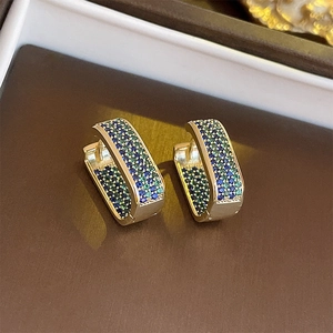 Macro detail of 14K gold plated earrings with blue and green micro-pave zircons