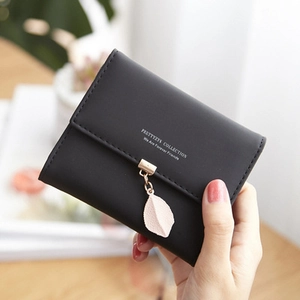 Close-up of black PU leather bifold wallet featuring a pink leaf pendant and gold hardware