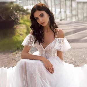 Elegant white lace wedding dress with V-neck, thin straps and shimmering tulle ball gown