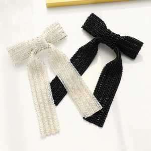 Detail of handmade beaded bow hair clips in black and white with 3D woven texture