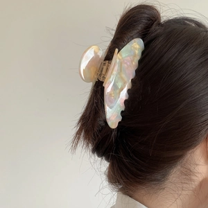Detailed view of an iridescent butterfly hair claw clip with a pearlescent finish