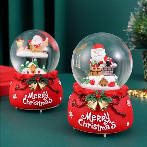 Set of two festive Christmas snow globes with Santa Claus on a decorative red base