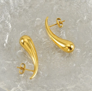 Detailed view of polished golden teardrop earrings with smooth glossy metallic finish