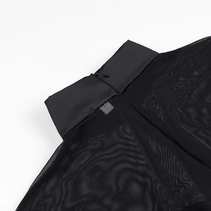 Gros plan du col montant en mesh noir avec fermeture éclair invisible et détails de texture