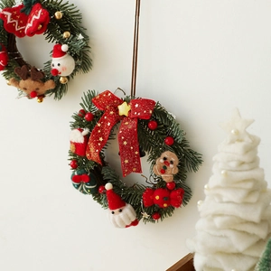 Christmas wreath with Santa and gingerbread man hanging on a white wall for holiday decor