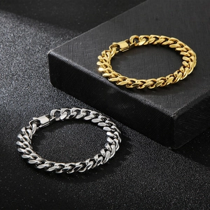 Gros plan de bracelets gourmettes en or et argent avec boucle en D sur fond noir