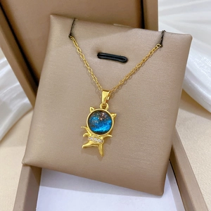 Detail of gold star cat necklace with blue stellar stone on a display stand