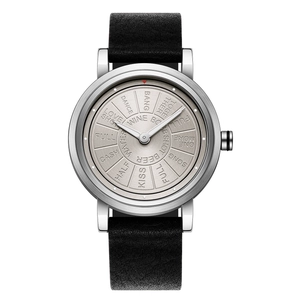 Detail of quartz watch silver dial featuring unique rotating engraved words and black leather strap