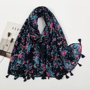 Flat lay of floral navy blue scarf with tassels, magazine and dried flowers on white