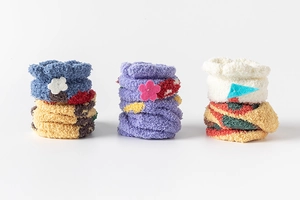 Detailed view of three pairs of thick coral fleece socks with colorful floral patterns