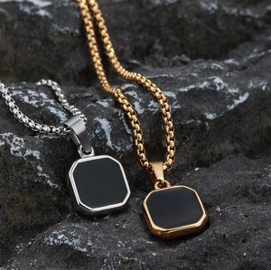 Square geometric pendant necklaces in gold and silver steel on a volcanic rock background