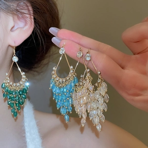 Macro view of crystal tassel earrings with colorful beads and gold diamond-set frame