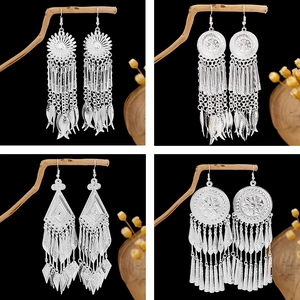 Bohemian silver tassel earrings featuring vintage geometric patterns on black background