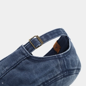 Detail of the adjustable brass buckle and stone-washed denim texture on back of the cap