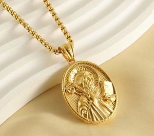 Macro detail of 18K gold plated St. Benedict pendant with 3D embossed relief on a chain