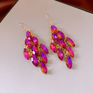 Macro shot of tiered magenta faceted gemstone tassel earrings with gold metal settings