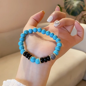 Close-up of bohemian beaded bracelet with blue turquoise and black onyx beads on wrist