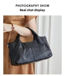 Close-up of black litchi pattern leather tote bag with silver metal hardware and fine stitching