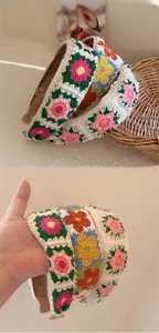 Detail of handmade crochet flower headband with colorful granny square knit patterns