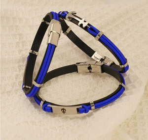 Détail du pendentif ancre sur bracelet tressé en cuir bleu et noir avec fermoir acier