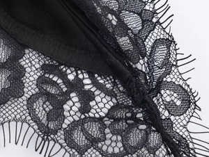 Detailaufnahme von filigraner schwarzer Wimpernspitze und Mesh-Gewebe auf dem Top