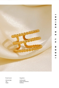 Detailed view of 3-layer gold plated beaded stackable ring on smooth silk fabric