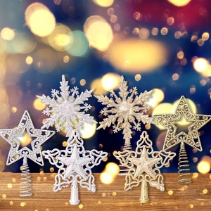 Golden and silver glitter star and snowflake Christmas tree toppers on wooden surface