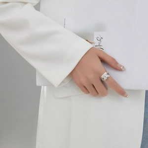 Close-up of irregular silver lava texture wide ring worn by a model in suit