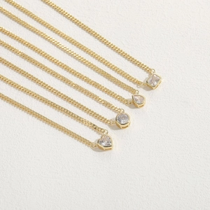 Elegant gold necklaces with heart, pear, round and rectangle zircon pendants on white background
