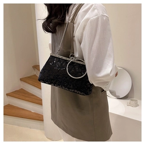 Close-up of black sequin handbag with sparkling silver rhinestone handle and chain
