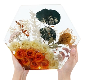 Close-up of hexagonal resin specimen with embedded yellow roses and dried flowers