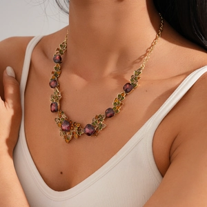 Close-up of vintage vine leaf necklace with deep red gems and colorful rhinestones
