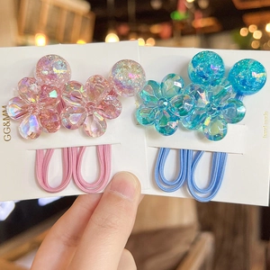 Close-up of pink and blue floral hair ties with iridescent petals on card display