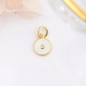 Macro detail of a round gold-plated eye pendant with enamel and zircon for jewelry DIY