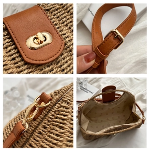 Detail der Strohtasche mit goldenem Drehverschluss und braunem Lederriemen im Fokus