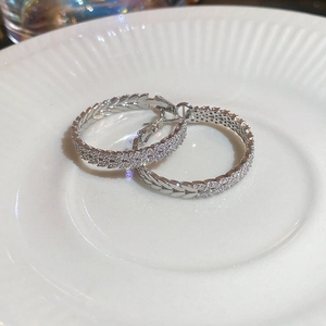 Detailed view of silver hoop earrings with leaf pattern and sparkling cubic zirconia